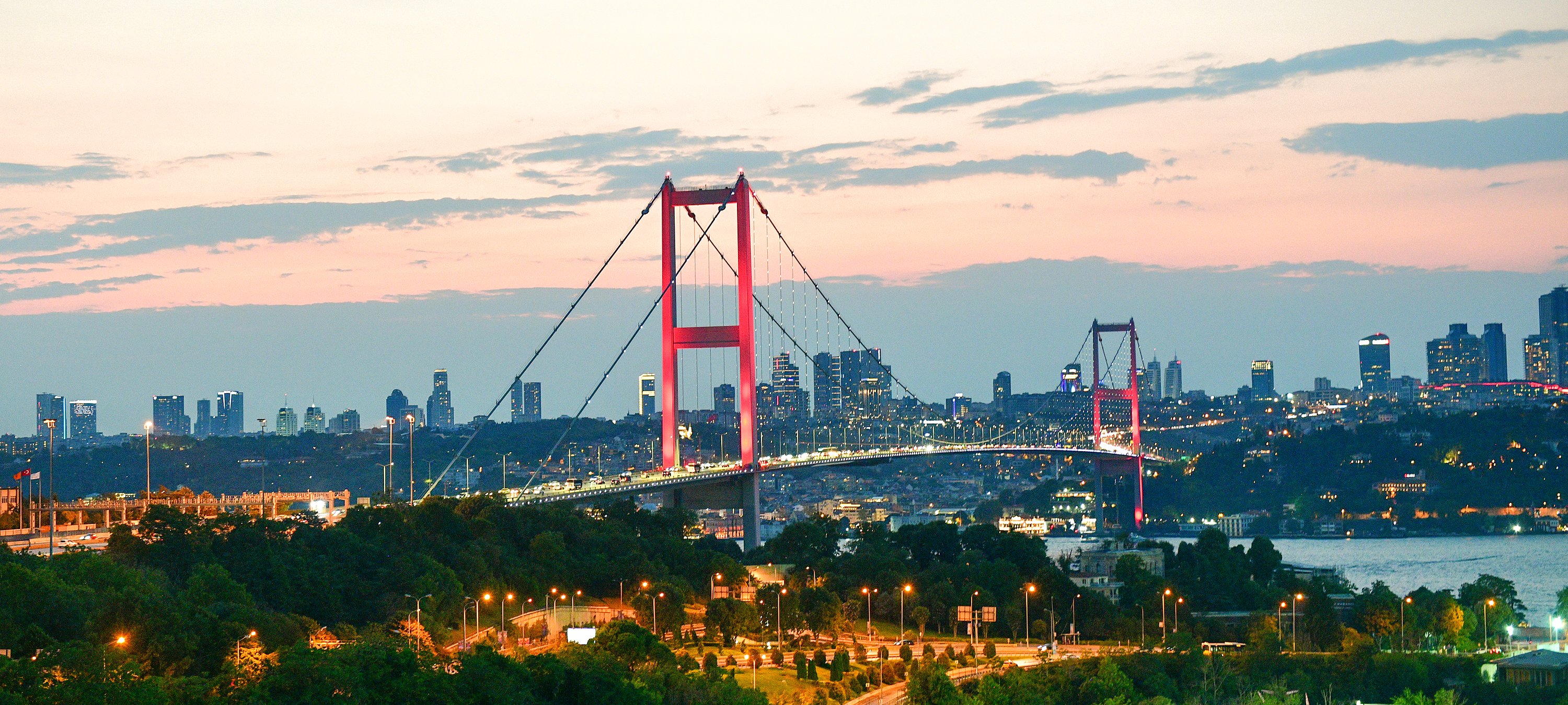 The Bosphorus Bridge at sunset with the Istanbul skyline and the sea below